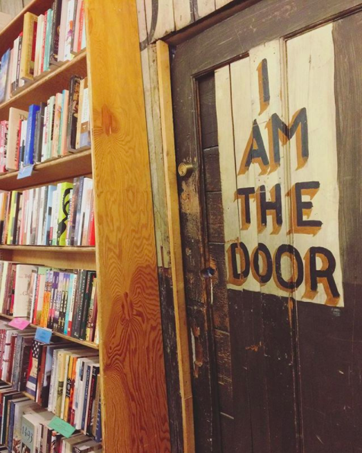 Old painted door that reads I AM THE DOOR 