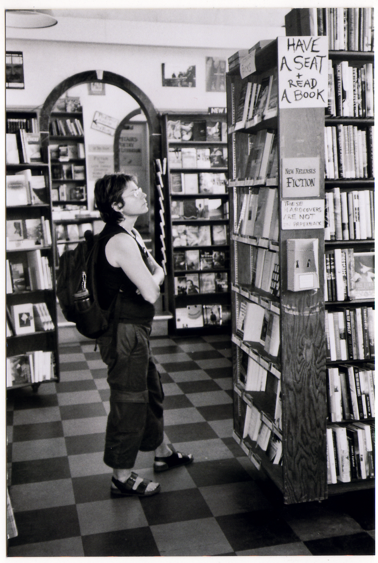 Woman studying a bookshelf in the City Light main room